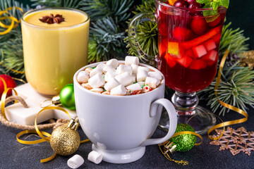 Set of traditional Christmas winter drinks. Christmas bar menu background.Tree cup with mulled wine, eggnog, hot chocolate beverages om dark background with Christmas, New Year decoration copy space.