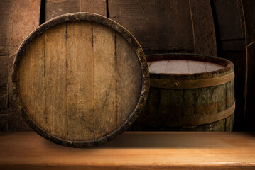 Excellent red wine bottles, wineglass, barrel and corkscrew on a rustic wooden table: traditional winemaking and wine tasting concept. High quality photo