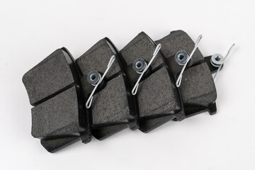 Set of new auto parts. New brake pads on a white background, copy the space. A set of brake parts....