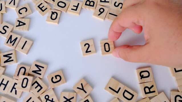 close-up of year change calendar with wood cube block tact 2023 on a light table, business concept, last quarter deadline, leave the past, plan for the future