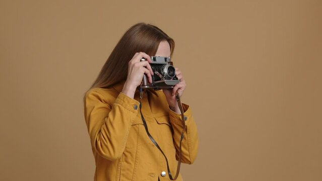 Caucasian, young woman taking pictures in the studio. Close-up view of a cheerful, smiling lady in her 20s during a photo session. High quality 4k footage