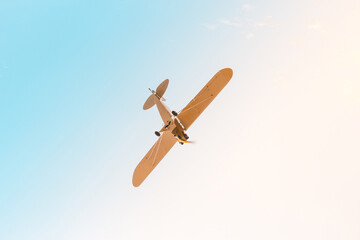 Retro plane with propeller flying across the sky in blue pink pastel colors