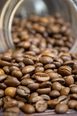 Spilled coffee beans from a glass jar. Selective focus.