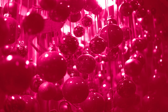 A lot of christmas ball decorations in Color of the year 2023 vibrates with vim and vigor magenta