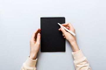 Woman hand with pencil writing on notebook. Woman working on office table. Female hand holding pencil and sketchbook. Mock-up Concept