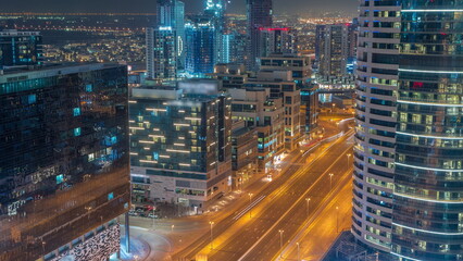 Fototapeta na wymiar Dubai's business bay towers aerial night timelapse. Rooftop view of some skyscrapers