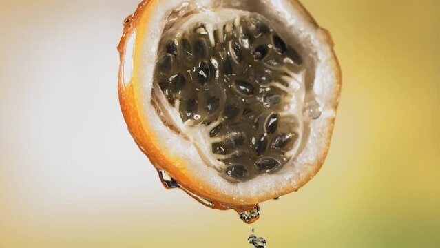 Slow Motion Macro Shot of Flowing Granadilla Juice from Halved Granadilla