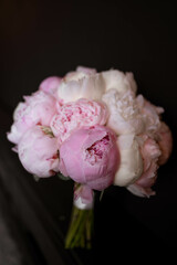 The bride's bouquet of pink peonies on dark backround.