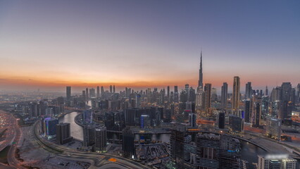Naklejka na ściany i meble Skyline with modern architecture of Dubai business bay towers day to night timelapse. Aerial view