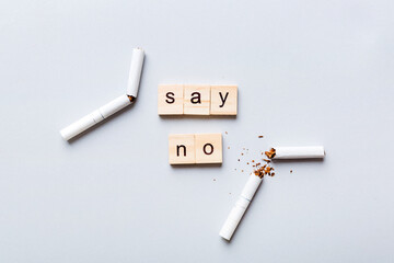 Cigarette And Wooden Blocks, Broken cigarette on table background, No Tobacco Day with hourglass, clock health concept. time to quit smoking