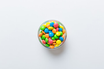 Multicolored candies in a bowl on a colored background. birthday and holiday concept. Top view with copy space