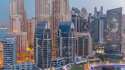 Dubai Marina skyscrapers and JBR district with luxury buildings and resorts aerial night to day timelapse