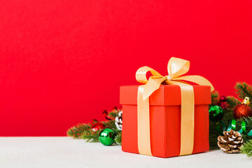 Obraz premium New Year Christmas mood, gift box, branches of a christmas tree, New Year decorations on a colored background