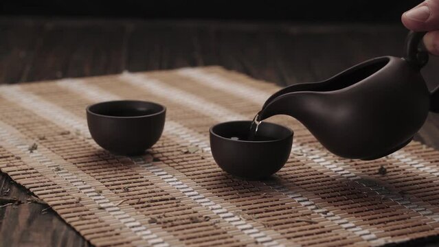 man offers a Chinese tea ceremony at home.