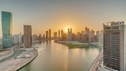 Fototapeta na wymiar Sunset cityscape of skyscrapers in Dubai Business Bay with water canal aerial timelapse