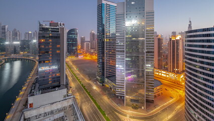 Obraz premium Cityscape of skyscrapers in Dubai Business Bay with water canal aerial night to day timelapse