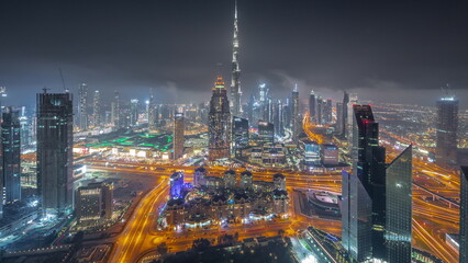 Fototapeta na wymiar Aerial view of tallest towers in Dubai Downtown skyline and highway all night timelapse.