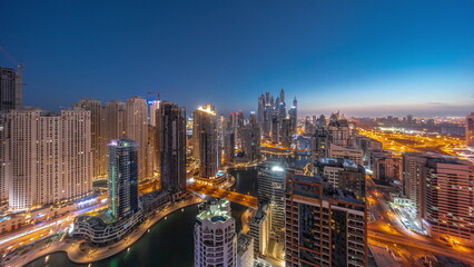 Fototapeta na wymiar Panorama of various skyscrapers in tallest recidential block in Dubai Marina aerial night to day timelapse