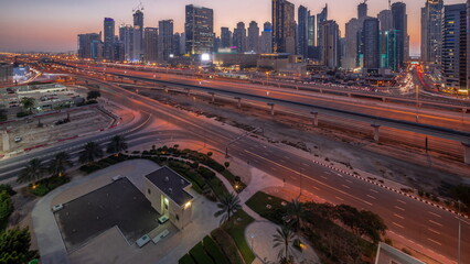 Dubai Marina skyscrapers and Sheikh Zayed road with metro railway aerial day to night timelapse, United Arab Emirates