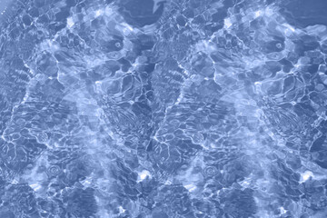 Defocus blurred transparent blue colored clear calm water surface texture with splashes and bubbles. Trendy abstract nature background. Water waves in sunlight with copy space. Blue watercolor shining