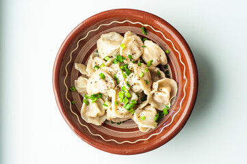 a classic traditional dish of pelmeni dumplings with meat, butter, pepper and greens, food of the countries of the world, gastrotourism