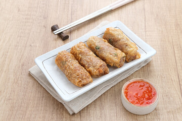 Lumpia Kulit Tahu, chicken shrimp spring rolls wrapped in tofu skin. Served with sauce.
