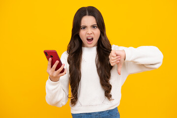 Teenage girl with smart phone. Portrait of teen child using mobile phone, cell web app. Angry face, upset emotions of teenager girl.