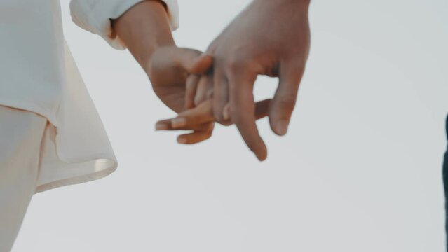 Close-up as white man and a woman in love tenderly holding hands. The concept of family, marriage, tenderness and relationships