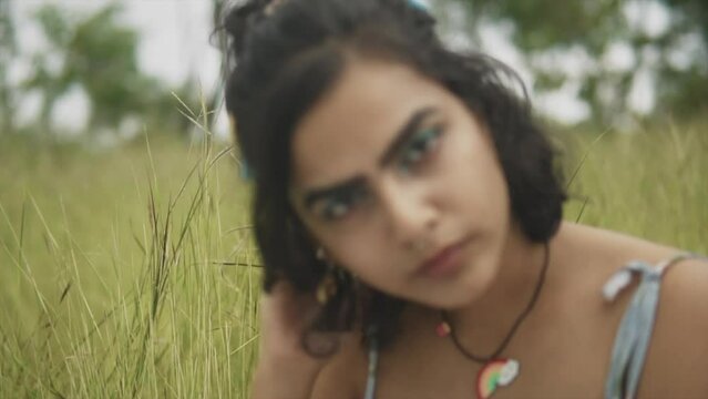 Beautiful Indian Girl looking at the camera. Intimate, focused. Green eye shadow make up. Light skin, sensual relaxing Women.