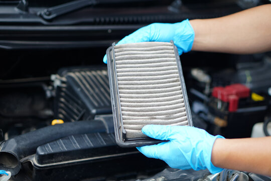 Closeup mechanic's hands hold air filter pad of car engine to check. Concept, car broken,repair and maintenace service. Dirty air fillter need to change for hygienic.                