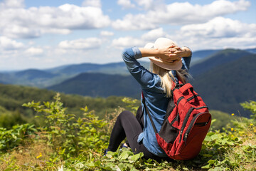 a woman rests after a hike in the mountains
