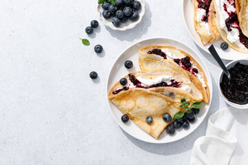 Crepes with blueberry jam, ricotta cheese and fresh berries. Pancakes for breakfast. Top view - 550856708