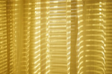 Sunny organza tulle with golden sunlight and blinds shadows