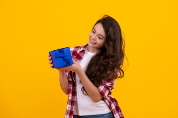 Happy teenager, positive and smiling emotions of teen girl. Child teen girl 12-14 years old with gift on isolated background. Birthday, holiday concept. Teenager hold present box.