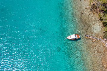 Aerial view of a small leisure boat on the turquoise water of Mediterranean Sea