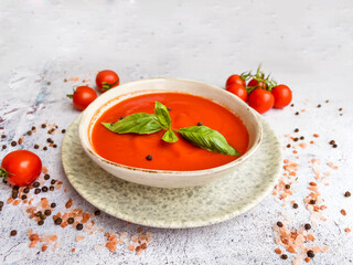 Tomato  soup with basil in a bowl on gray textured background .Gazpacho (gaspacho) cold soup  