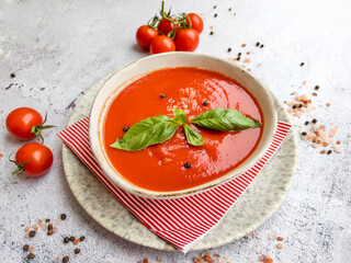 Tomato  soup with basil in a bowl on gray textured background .Gazpacho (gaspacho) cold soup  