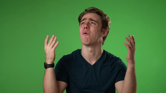 Angry, scared young man 20s put hands on head screaming crying ask why me, isolated on green screen background studio. People lifestyle concept in slow motion