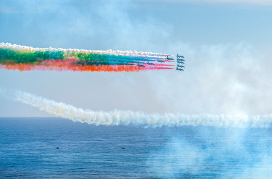 Frecce Tricolori air showAir show of the Frecce Tricolori aerobatic team of the Italian Air Force with colored smoke trails in front of partly clouded sky