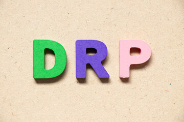 Color alphabet letter in word DRP on wood background