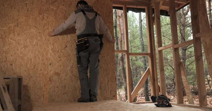 Man worker building wooden frame house