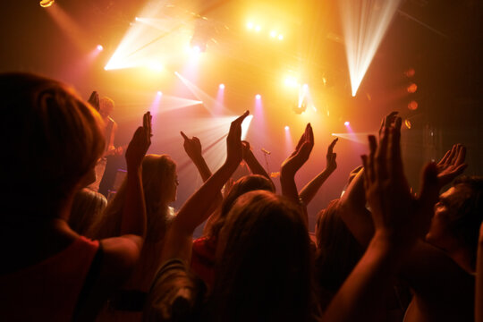 Music rock festival, concert or performance event with audience, crowd or people hands dancing with fans, youth and friends. Group of people at a techno, disco rave or night party club in celebration