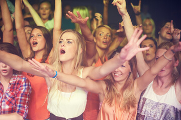 Concert, music festival and crowd of women or audience in night club, dance event and singing...