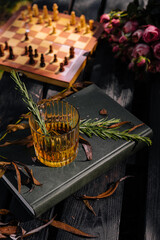 Whiskey in a glass with ice and a chessboard