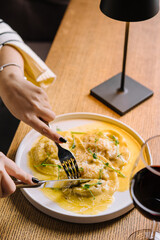 woman eating ravioli with parmesan cheese