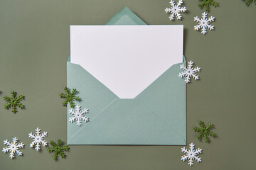 Christmas card flat lay. Empty card in green envelope. Mockup.