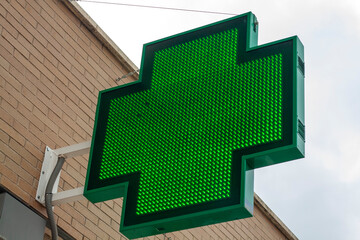 luminous green cross indicating that a pharmacy remains open in the city of Madrid