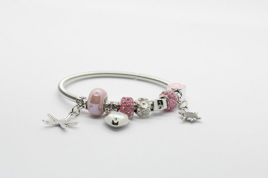 Close-up shot of a silver Pandora hand bracelet with charms isolated on a white background