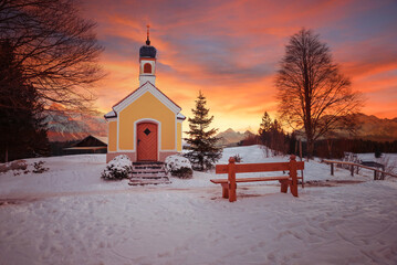 pilgrimage chapel in snowy winter landscape, colorful sunset scenery upper bavaria