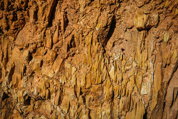 Red rock texture background for design. Details of mountain surface, close-up. Abstract  natural stone pattern.